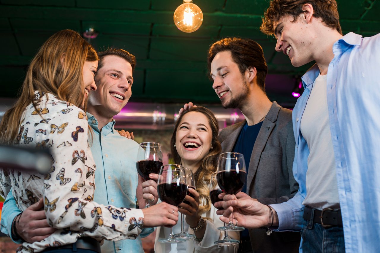 Grupa przyjaciół przy wieczornych drinkach w barze